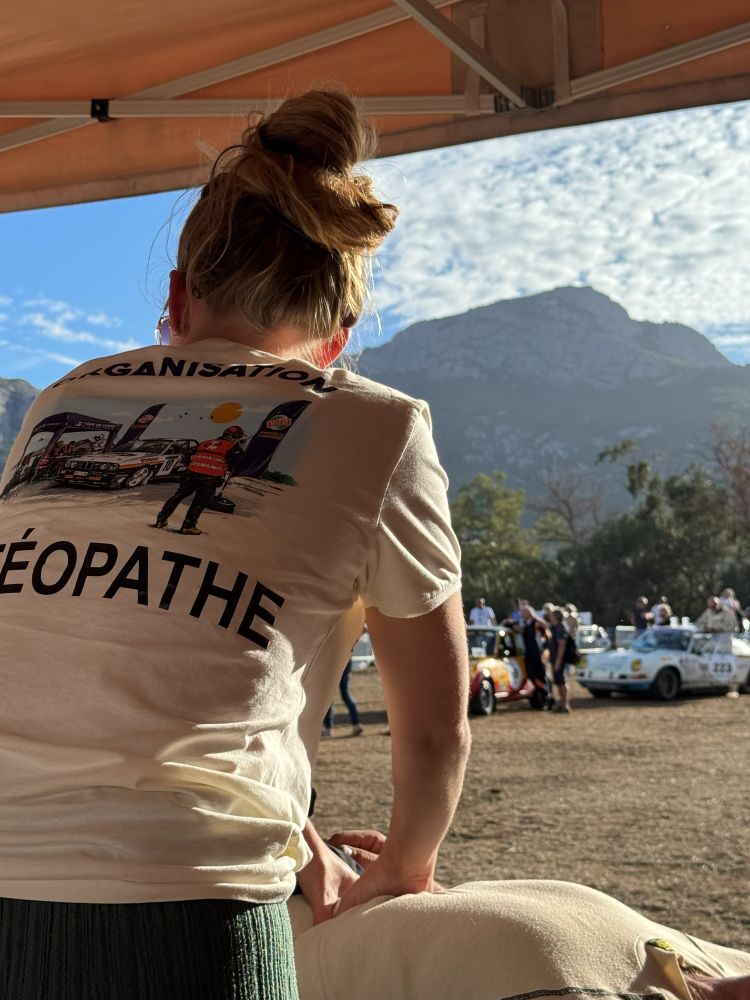 Laurina de dos, tee-shirt « Ostéopathe » de l'organisation, au parc d'assistance du Tour de Corse Historique